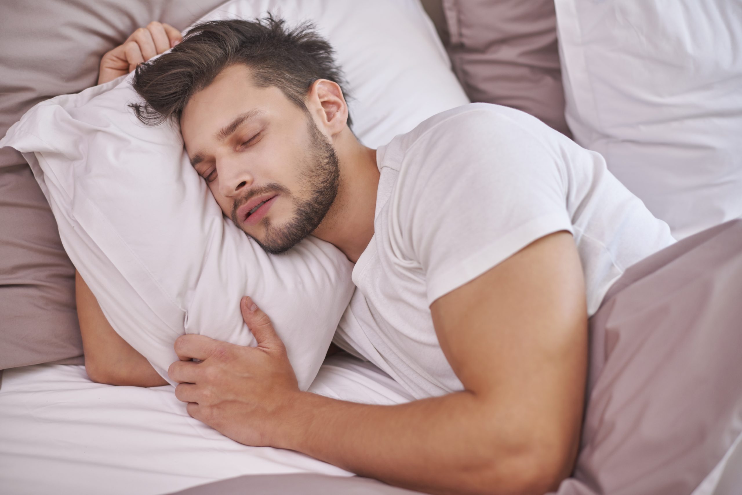 Exhausted man sleeping in his bed